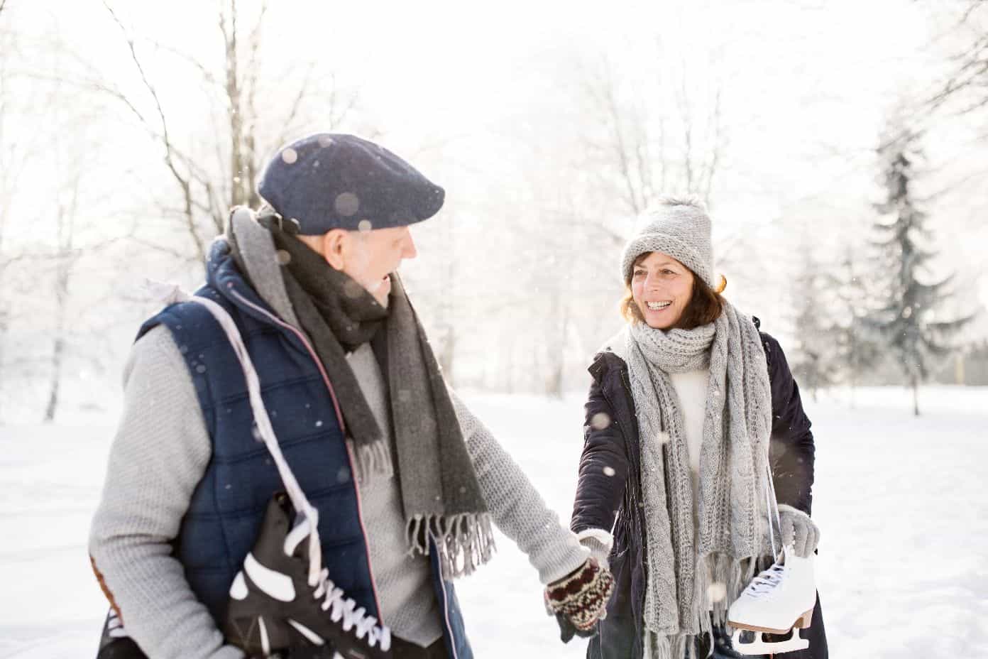 Un homme et une femme se tiennent la main, il neige.