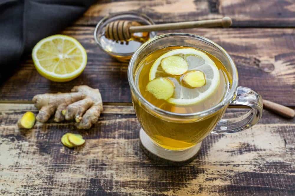 verre avec une tisane chaude, citron et gingembre