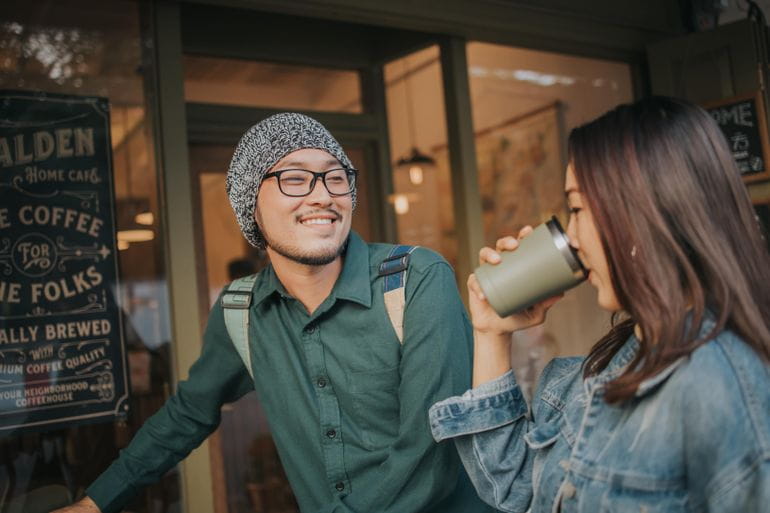 Un homme regarde une femme entrain de boire.